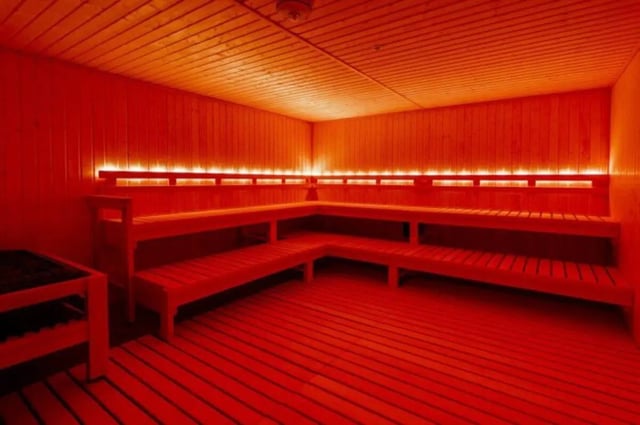 Wooden sauna benches with red lighting Sauna at Ari on Fourth in Tucson Student Accommodation