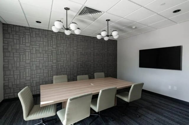 Long table chairs modern wall mounted TV meeting room at Ari on Fourth in Tucson Student Accommodation
