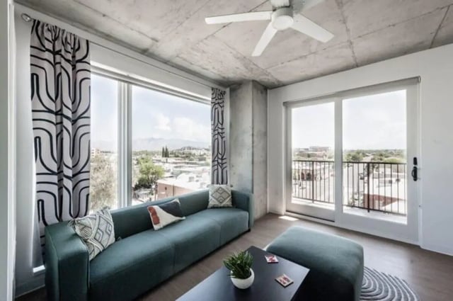 Green sofa patterned curtains large windows living room at Ari on Fourth in Tucson Student Accommodation