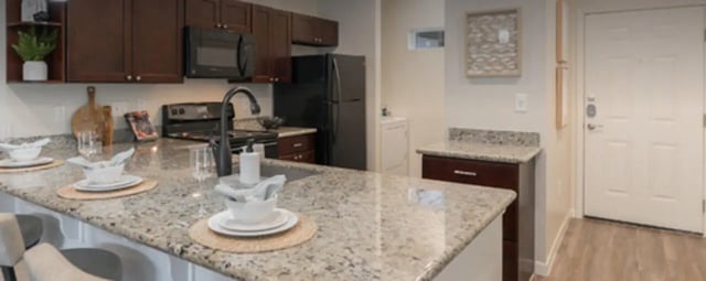 Kitchen with dark cabinets granite countertops and appliances kitchen at Regency Gardens in Bryan Student Accommodation