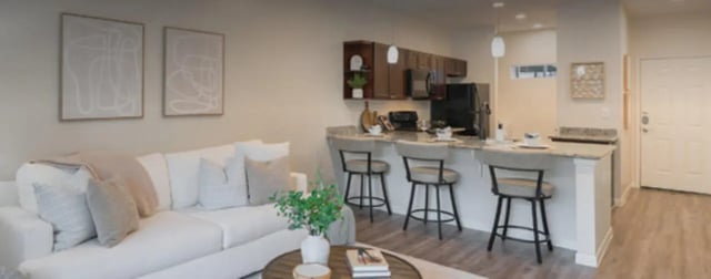 White sofa kitchen island bar stools living area at Regency Gardens in Bryan Student Accommodation