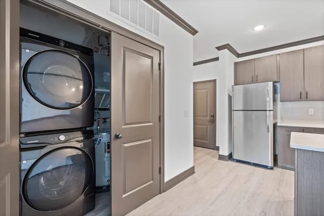 Stacked Samsung washer dryer and stainless steel refrigerator kitchen at Parkville Flats in Parkville Student Accommodation