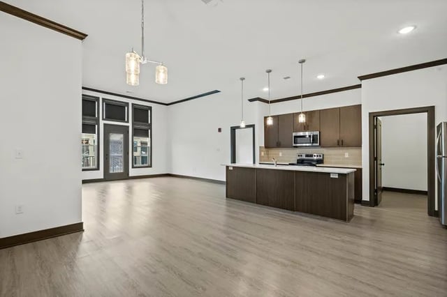 Modern kitchen island with cabinets appliances and living area Kitchen at Parkville Flats in Parkville Student Accommodation
