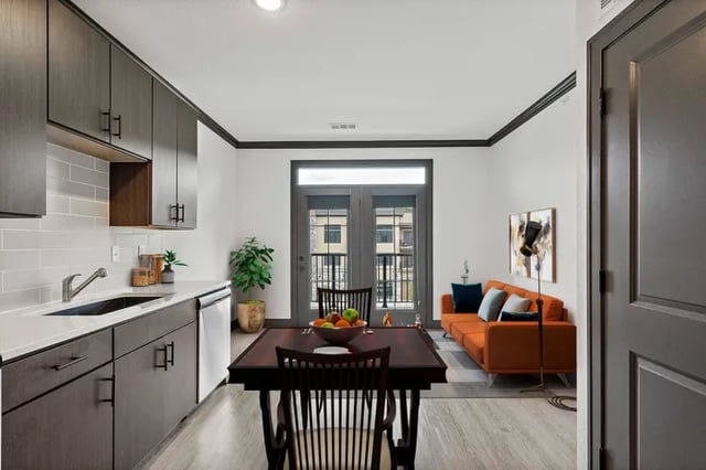 Kitchen with orange sofa and dining table living room at Parkville Flats in Parkville Student Accommodation