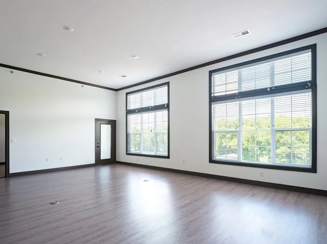 Large windows wooden floor door empty living room at Parkville Flats in Parkville Student Accommodation