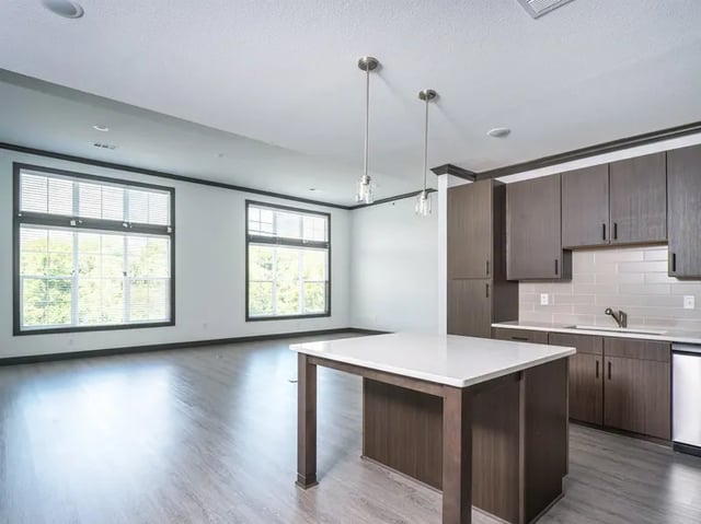 Kitchen island with cabinets and large windows living area at Parkville Flats in Parkville Student Accommodation