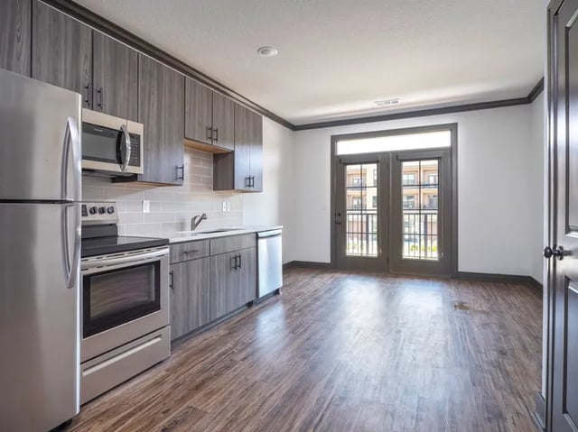 Stainless steel appliances gray cabinets white counters kitchen living area at Parkville Flats in Parkville Student Accommodation