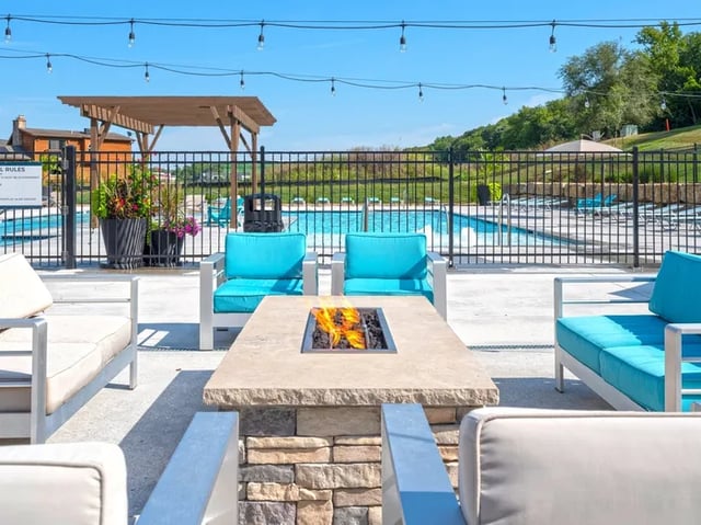 Fire pit poolside seating with blue cushions exterior at Parkville Flats in Parkville Student Accommodation
