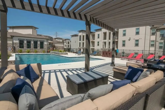 Outdoor seating by pool with lounge chairs exterior at Riverside Villas in Fort Worth Student Accommodation