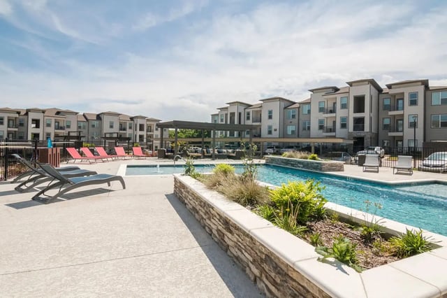 Pool lounge chairs apartments exterior living area at Riverside Villas in Fort Worth Student Accommodation
