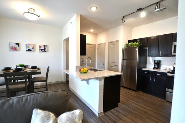 Dining table island with chairs and kitchen appliances kitchen at Riverside Villas in Fort Worth Student Accommodation