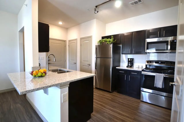 Kitchen with granite island and stainless steel appliances Kitchen at Riverside Villas in Fort Worth Student Accommodation