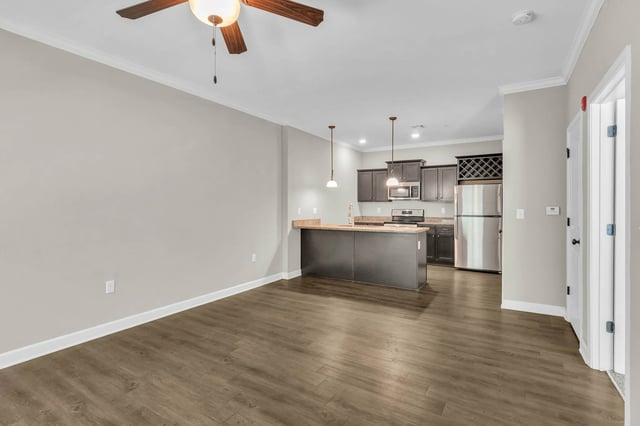 Kitchen island, stainless steel refrigerator, and cabinets living room at Woodhaven Apartment Living in Kansas City Student Accommodation