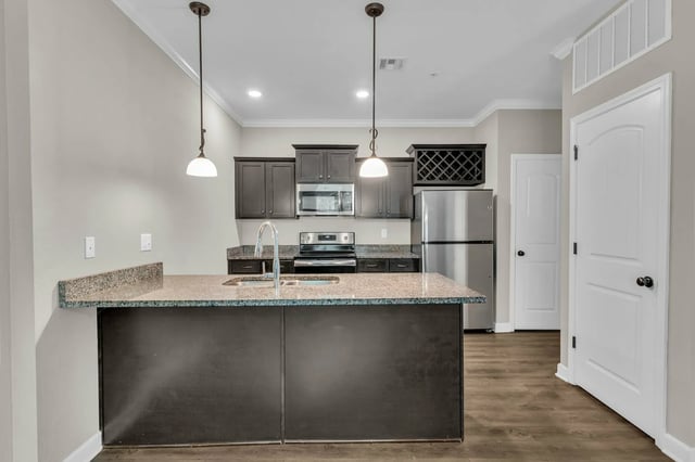 Granite island with sink stainless steel appliances kitchen at Woodhaven Apartment Living in Kansas City Student Accommodation
