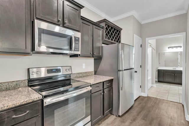 Stainless steel appliances, dark cabinets, wine rack kitchen at Woodhaven Apartment Living in Kansas City Student Accommodation