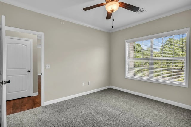 Door ceiling fan blinds bedroom at Woodhaven Apartment Living in Kansas City Student Accommodation