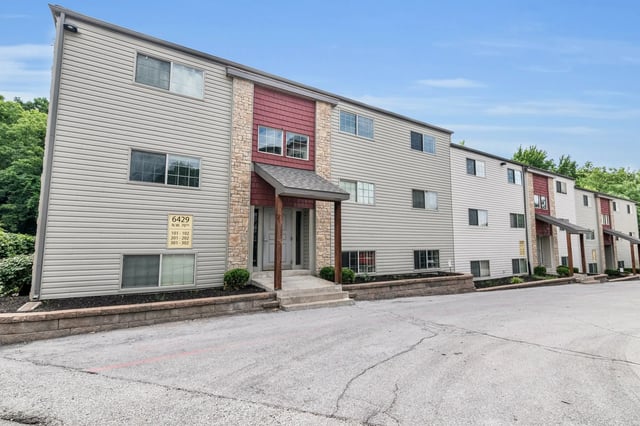 Apartment building with vinyl siding and stone exterior exterior at Woodhaven Apartment Living in Kansas City Student Accommodation