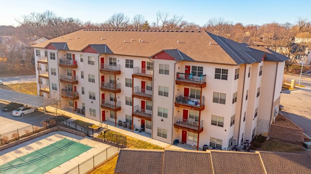 Apartment building with balconies parking pool exterior at Woodhaven Apartment Living in Kansas City Student Accommodation