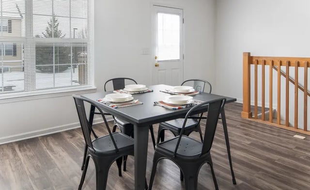 Table four chairs placemats plates dining room at Canvas Townhomes in Allendale Student Accommodation
