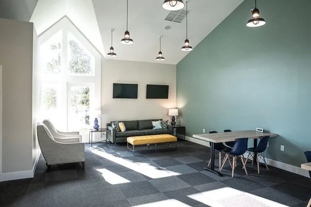 Sofa yellow ottoman two chairs dining table chairs living room at Canvas Townhomes in Allendale Student Accommodation