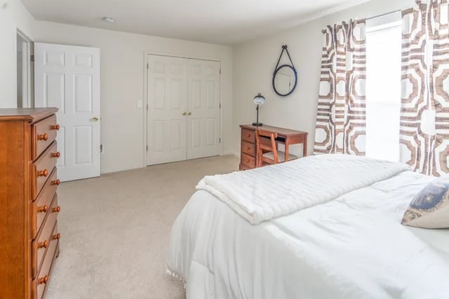 Dresser desk chair mirror white bed Bedroom at Canvas Townhomes in Allendale Student Accommodation