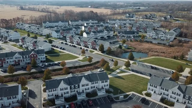 Townhouses with parking lots and pond exterior at Canvas Townhomes in Allendale Student Accommodation