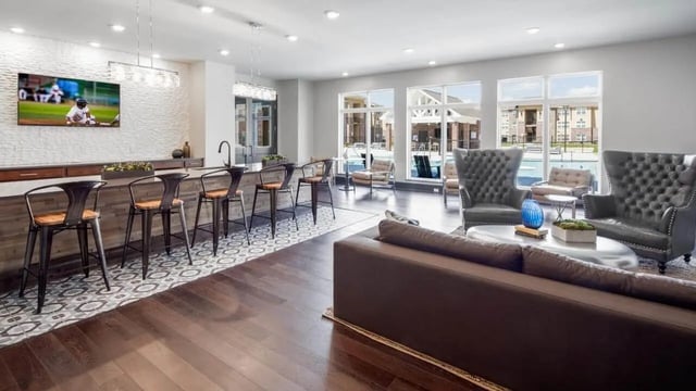 Bar with stools and couches overlooking pool Living area at Locale Student Housing in Allendale Student Accommodation