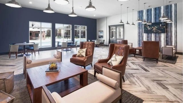 Leather chairs coffee table and sofa living room at Locale Student Housing in Allendale Student Accommodation