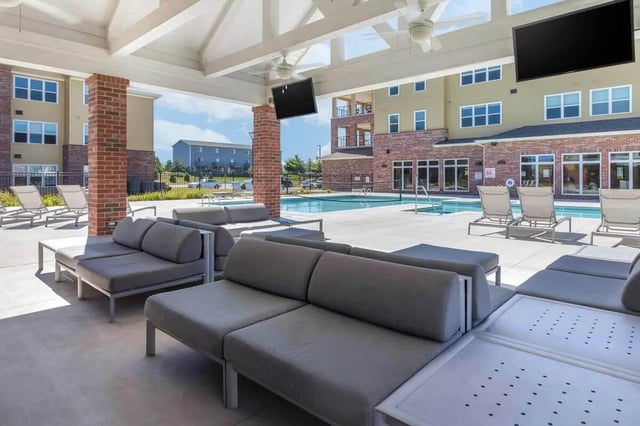 Gray lounge seating near a swimming pool exterior at Locale Student Housing in Allendale Student Accommodation