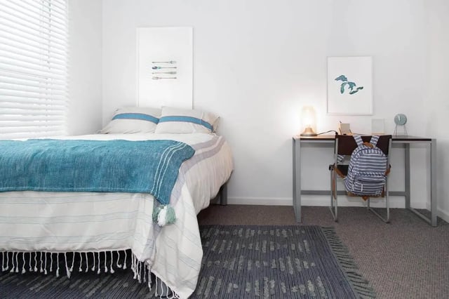 Bed desk backpack lamp wall art bedroom at Locale Student Housing in Allendale Student Accommodation