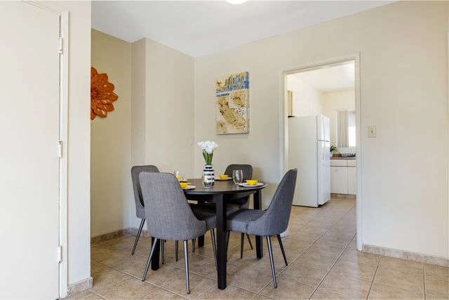 Round dining table with four chairs kitchen area dining room at College Campanile in San Diego Student Accommodation
