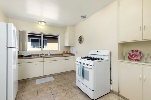 White refrigerator stove sink cabinets kitchen at College Campanile in San Diego Student Accommodation