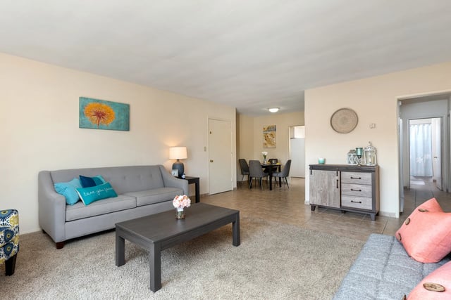 Gray sofa coffee table dining area living room at College Campanile in San Diego Student Accommodation