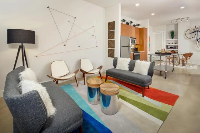Modern living room with gray sofa and chairs living room at The Flats at Big Tex in San Antonio Student Accommodation