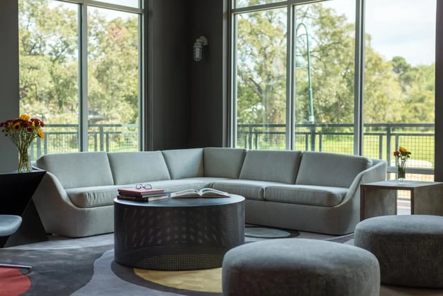 Sectional sofa coffee table books large windows living room at The Flats at Big Tex in San Antonio Student Accommodation