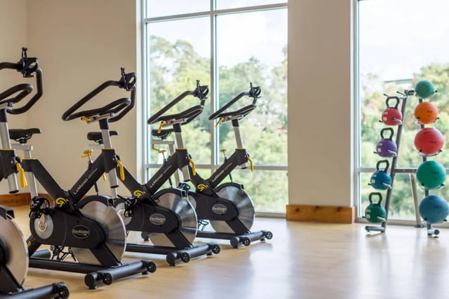 Spin bikes and colorful weights gymnasium at The Flats at Big Tex in San Antonio Student Accommodation