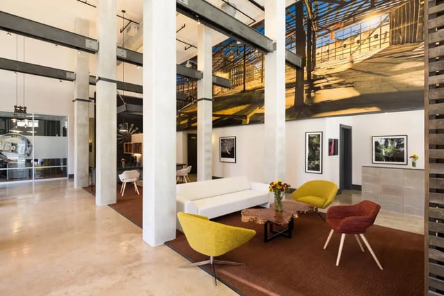 White sofa yellow chairs wood table living room at The Flats at Big Tex in San Antonio Student Accommodation