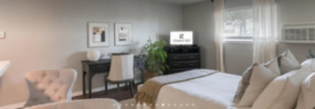 Bed desk chairs television and plant bedroom at The Grand 1501 in College Station Student Accommodation