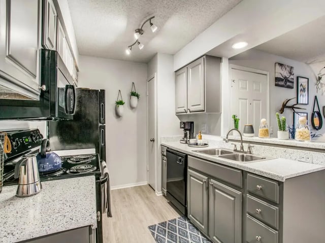 Kitchen with black appliances and grey cabinets kitchen at The Joseph at Huebner in San Antonio Student Accommodation