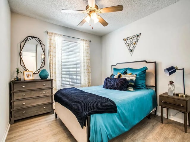 Bed dresser mirror lamp and wall decor bedroom at The Joseph at Huebner in San Antonio Student Accommodation