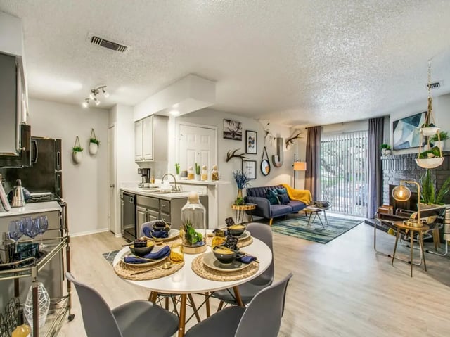Dining table chairs kitchen and living room at The Joseph at Huebner in San Antonio Student Accommodation