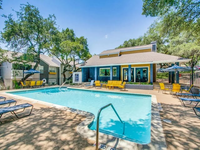 Pool area with lounge chairs and yellow seating area. at The Joseph at Huebner in San Antonio Student Accommodation