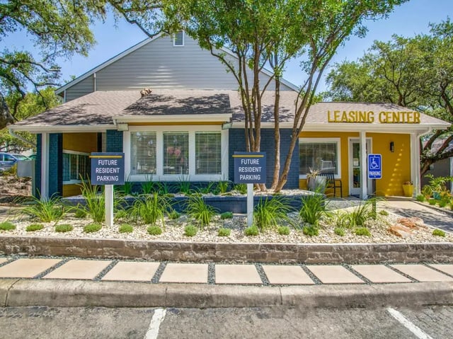 Leasing center building with parking signs exterior at The Joseph at Huebner in San Antonio Student Accommodation