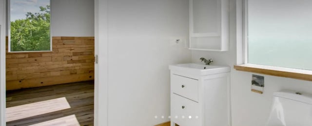 White vanity sink wooden walls and toilet bathroom at The Lofts at 305 in Bryan Student Accommodation