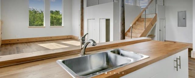 Double sink faucet wooden counter open plan kitchen at The Lofts at 305 in Bryan Student Accommodation