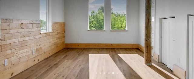 Wooden accent wall floor and double doors living room at The Lofts at 305 in Bryan Student Accommodation