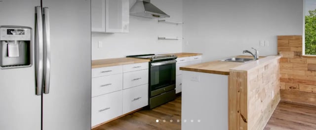 Refrigerator stove cabinets countertop sink kitchen at The Lofts at 305 in Bryan Student Accommodation
