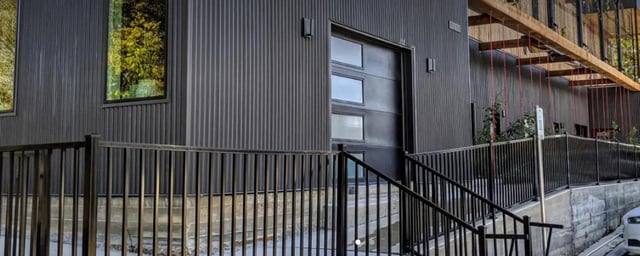 Modern exterior with black metal siding and garage door exterior at The Lofts at 305 in Bryan Student Accommodation