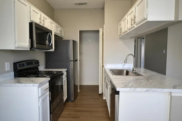 Modern kitchen with stainless steel appliances and white cabinets kitchen at The Oaks of Arlington in Arlington Student Accommodation