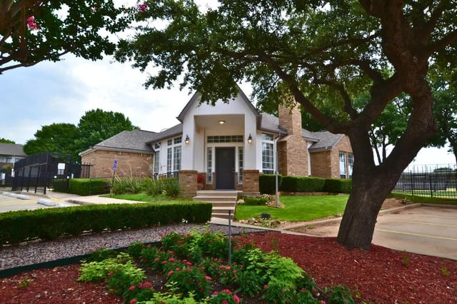 Brick building entrance with landscaping exterior at The Oaks of Arlington in Arlington Student Accommodation